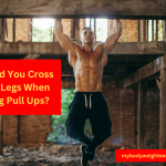 A Muscular Man Performing Pull Ups With His Legs Crossed