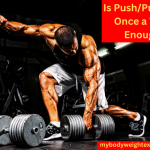 A Muscular Man Performing Single-Arm Dumbbell Rows in the Gym